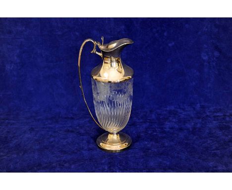 A George V silver claret jug with pierced thumb piece to the cover and loop handle, the swirled glass lower section with etch