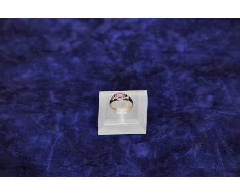 A 9ct gold ring set with a central amethyst, flanked by two diamond chips to each shoulder. 