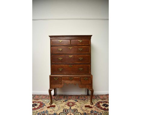 A George III cross-banded oak chest on standThe cavetto cornice above two short and three long graduated, cross-banded and co