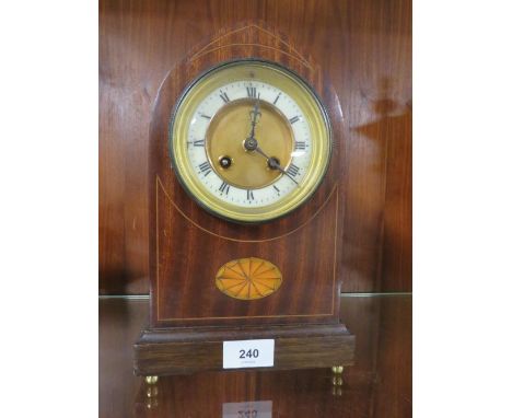 An inlaid domed mantle clock on four brass bun feet 
