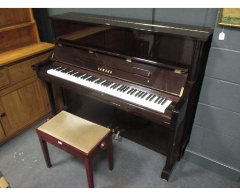 A modern Yamaha upright pianoforte in a mahogany case together with a stool (2)  