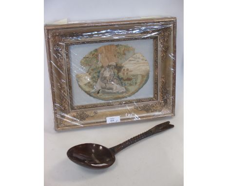 A carved wooden spoon and a needlework picture  