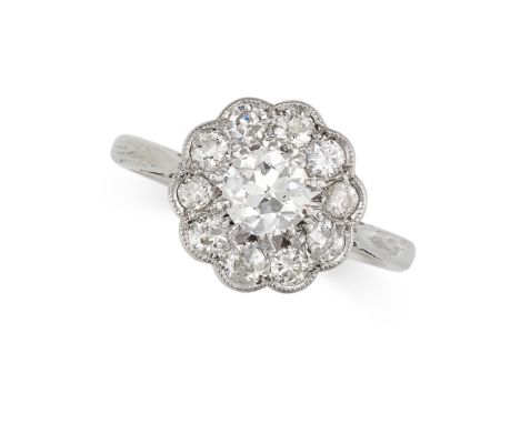 A DIAMOND CLUSTER DRESS RING in 18ct gold, set with a principal old cut diamond of 0.54 carats within a scalloped border of f