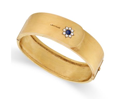 AN ANTIQUE SAPPHIRE AND PEARL BANGLE in yellow gold, set with a round cut sapphire in a cluster of pearls, no assay marks, in