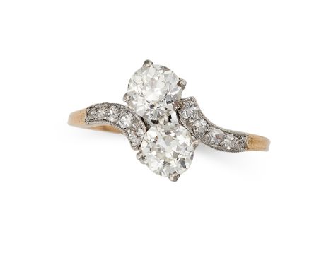 A DIAMOND TOI ET MOI RING, EARLY 20TH CENTURY in 18ct yellow gold and platinum, the stylised band terminated at either end wi