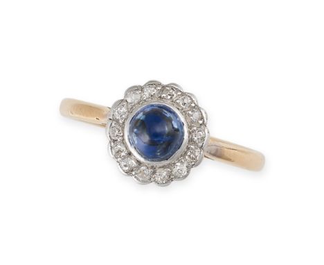 A SAPPHIRE AND DIAMOND CLUSTER DRESS RING in 18ct yellow gold and platinum, set with a round cabochon blue sapphire of 0.97 c