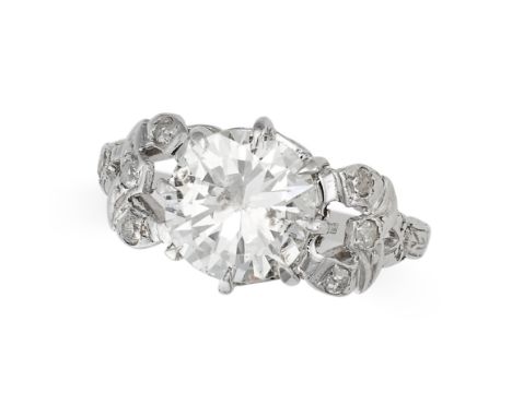 A SOLITAIRE DIAMOND DRESS RING in platinum, set with an old European brilliant cut diamond of 1.80 carats, between stylised s