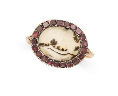 AN ANTIQUE DENDRITIC AGATE AND GARNET RING in yellow gold, set with an oval cabochon cut piece of dendritic agate, within a b