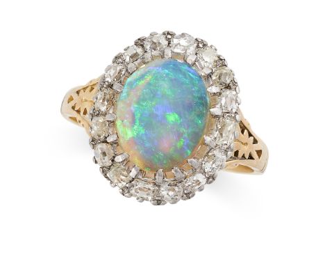 AN OPAL AND DIAMOND CLUSTER DRESS RING in yellow gold and silver, set with an oval cabochon opal within a border of old cut d