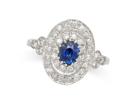 A SAPPHIRE AND DIAMOND DRESS RING in platinum, set with an oval cut sapphire within two concentric rows of round brilliant cu