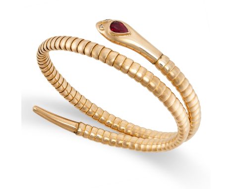 A VINTAGE RUBY AND DIAMOND SNAKE BANGLE in yellow gold, the articulated body designed to depict a snake coiled around on itse