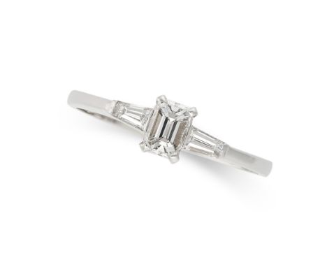 A DIAMOND RING in 18ct white gold, set with an emerald cut diamond accented by two tapering baguette cut diamonds, full Briti