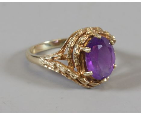 A 9ct gold ring with faceted amethyst stone in bamboo effect setting size J.