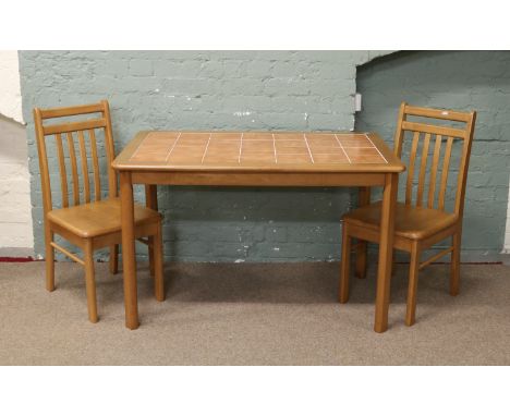 A tile top dining table and two chairs.