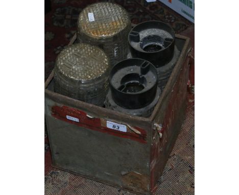 A metal box containing a set of four 1940s light shades with bakelite mounts.