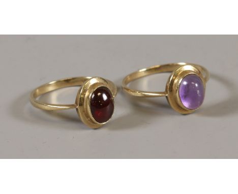 Two similar 9ct gold rings, one set with a cabachon amethyst the other a garnet, amethyst O garnet M.