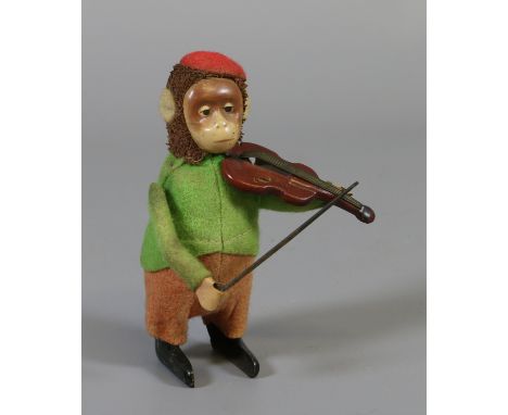 A vintage German clockwork model of a monkey playing a violin.