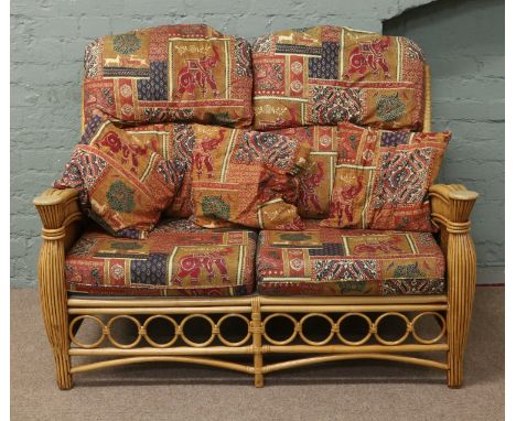 A rattan and upholstered conservatory suite comprising of a two seat sofa and two arm chairs.