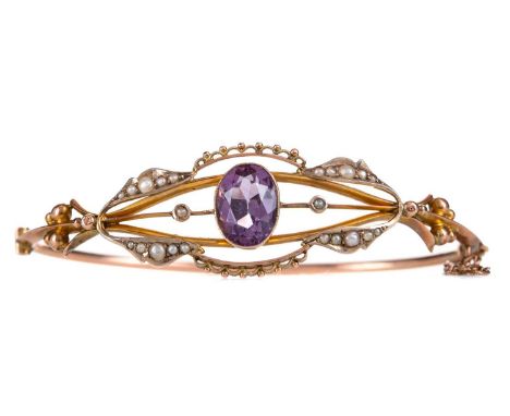 EDWARDIAN AMETHYST AND PEARL BANGLE,set with central oval amethyst within an openwork border of seed pearls, marked 9CT, 6.9g
