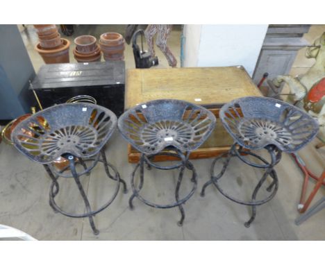 A set of three cast iron tractor seat stools 