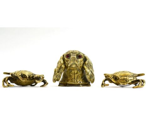 A Victorian Brass Inkwell, modelled as the head of a dog with glass eyes, 10.5cm high; and A Pair of Inkwells, modelled as cr