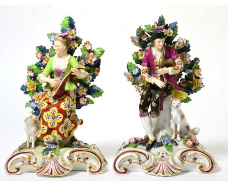 A Pair of Chelsea Style Porcelain Figures of a Shepherd and Shepherdess, circa 1900, each sitting playing a musical instrumen