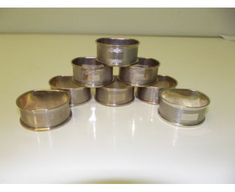 Set of eight contemporary silver 'D' shaped napkin rings, engine turned with vacant cartouches, Birmingham, W I Broadway &amp