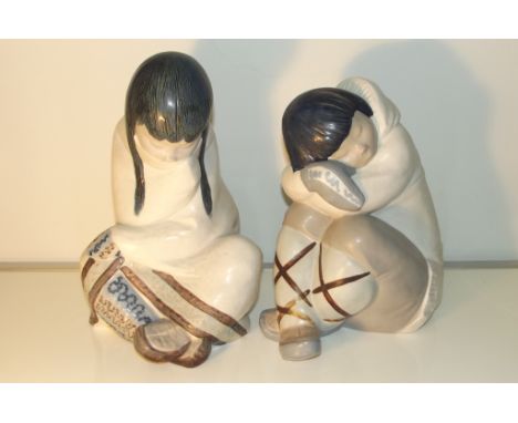 A pair of Lladro figures modelled as huddled Eskimos with one boy and girl. Impressed marks to underside. Height of girl 30cm
