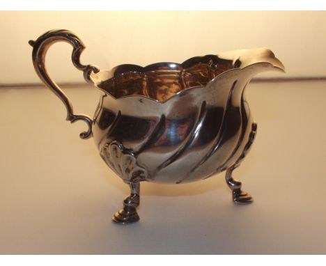 A silver cream jug on tripod feet, Walter &amp; John Barnard, London 1893.106 grams.