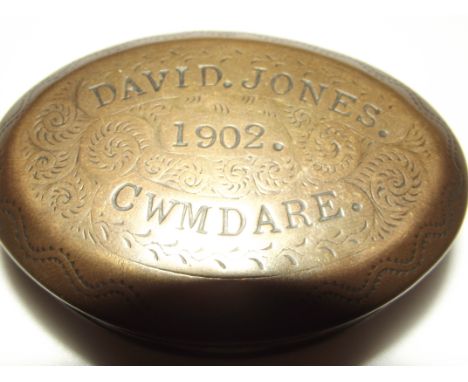 Miners brass snuff box of oval form, the hinged lid with engraved decoration. David Jones 1902. Cwmdare. 8cm in length