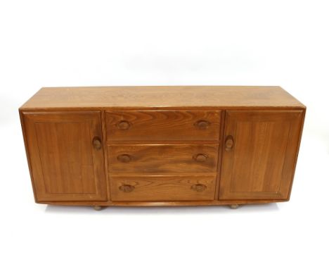 A medium Ercol sideboard, fitted three central drawers flanked by cupboards, 155cm wide 
