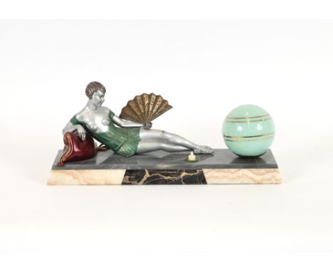 An Art Deco lamp, in the form of a semi naked girl holding a fan, and reclining on a cushion, the marble base signed "Ballest