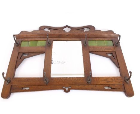 An Art Nouveau oak and green tile back wall mounting coat rack, 95cm wide