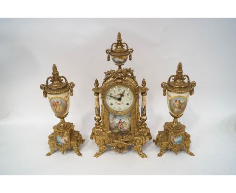 A 20th century cast brass clock garniture with painted porcelain panels on a pale yellow ground, the clock with eight day Ger