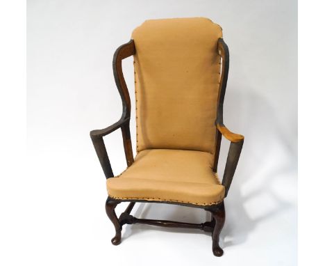 An early 18th century wing armchair with covers, partially restored with cabriole legs, linked by turned stretchers, the orig