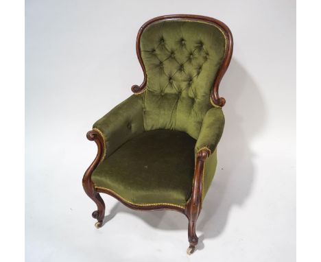 A Victorian mahogany button back armchair with carved frame, upholstered in green dralon and standing on cabriole legs