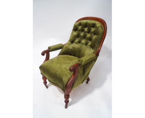A Victorian mahogany framed button back armchair on turned legs with ceramic casters