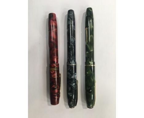 Two Conway Stewart fountain pens with blue and green marbled cases, lever filling system, both with 14ct gold nibs, and an Os