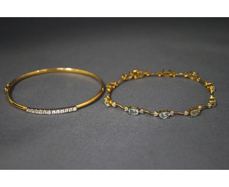 A 9 carat gold cubic zirconia set bangle; and a blue topaz and diamond bracelet; 9.7 g gross