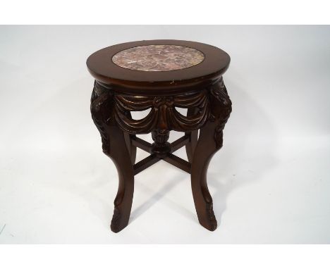 A 20th century continental occasional table, with inset marble top on four carved legs, linked by a X stretcher with ball fin