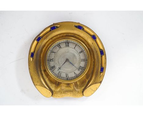 A Howell and James brass and enamel desk clock, in the form of a horseshoe, the central dial panel with engine turned decorat