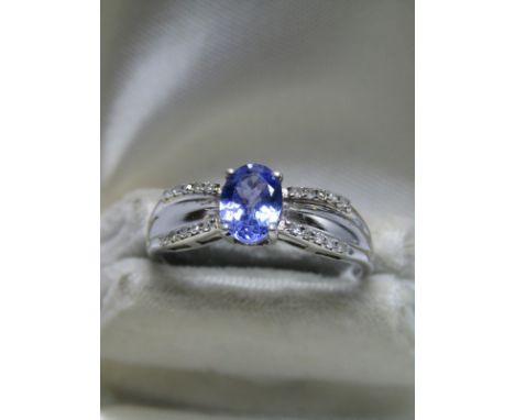 9ct WHITE GOLD TANZANITE &amp; DIAMOND RING, central oval cut tanzanite in 4 claw setting with accent diamonds to each should