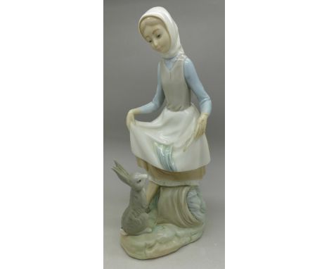 A Lladro figure of a woman with hare, D-75, height 23cm