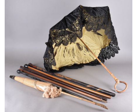 A collection of late 19th and 20th Century walking canes and parasols including an Asian carved bamboo cane with decorative s