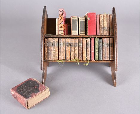 A set of miniature leather bound Shakespeare volumes in an oak book trough, 23 cm wide. Together with various Bryant &amp; Ma