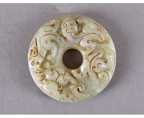 A Chinese jade pendant, of disc shape decorated with bats, salamanders and mythical bird like figures, with pierced centre, 6