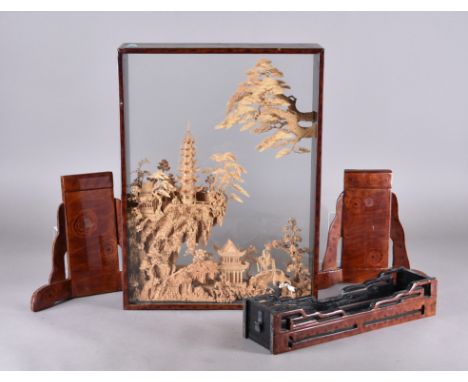 A modern Chinese cork diorama, within a lacquered display case, modelled as pagodas within mountainous landscape, on bracket 
