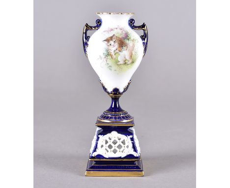 A Royal Worcester twin handled vase on ornate pierced plinth base decorated with kitten amongst flowers by C Baldwyn, blue un