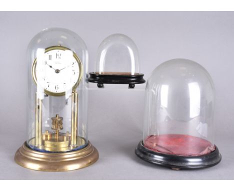 A 19th Century glass dome and plinth, 25 cm high together with another smaller, 15 cm high and a domed 100 hour brass mantel 