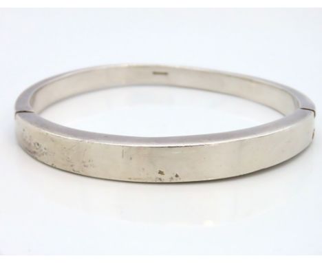 A heavy gauge plain silver bangle, 65mm x 56mm internally, 64g